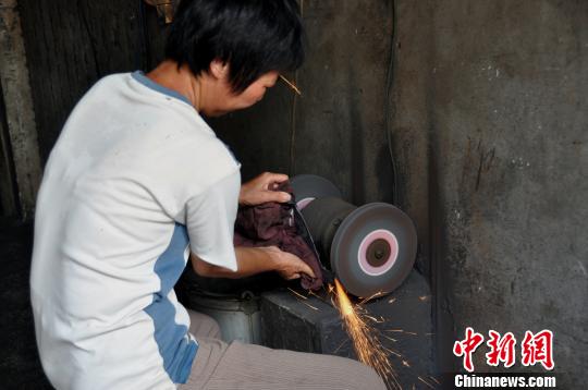 妻子正在打磨鐵器。 鄧歡 攝